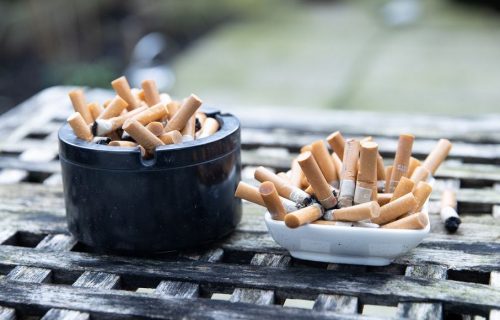 Two ashtrays filled to overflowing with cigarette butts.