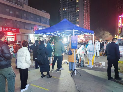 A long line approaches a tent set up as a covid testing site, Landis City, Beilin District, Xi'an City, December 17, 2021