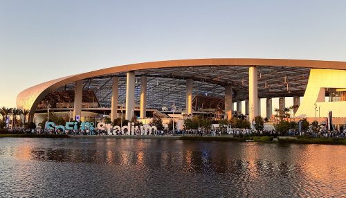 Looking across water at the exterior of SoFi Stadium in November 2021