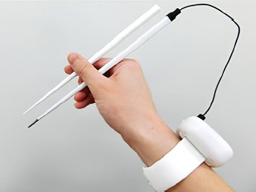 An image of a hand holding electric chopsticks, with a battery pack on the wrist.