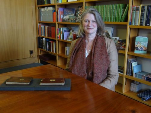 Librarian Jessica Gardner poses with two of Charles Darwin's missing notebooks after they were returned to the Cambridge University Library.