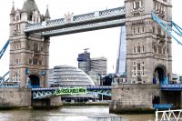 Extinction Rebellion protesters hang a sign saying 'End Fossil Fuels Now' from the side of Tower Bridge in London on April 8, 2022.