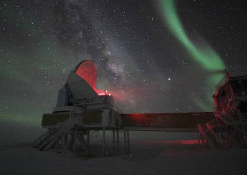 Aurora australis ("southern lights") blankets the sky overhead of the 10-meter South Pole Telescope at Amundsen-Scott South Pole Station, Antarctica. The telescope collects data on cosmic microwave background radiation and black matter.