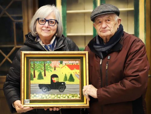Irene and Tony Demas pose with their Maud Lewis painting, "Black Truck".
