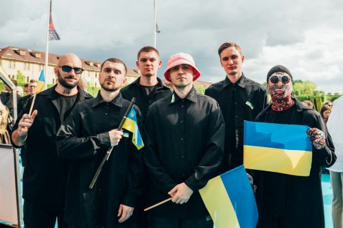 Ukraine’s Kalush Orchestra seen in Turin in May, 2022, wearing black and carrying Ukrainian flags..