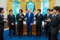 BTS meets with US President Joe Biden at the White House. The band members laugh as Mr. Biden smiles and points a finger at one of the band's members.