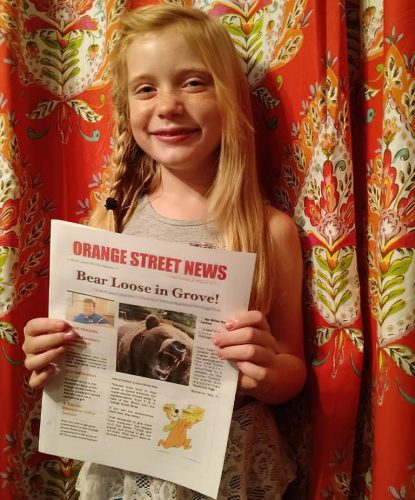 Hilde Lysiak poses with a copy of the Orange Street News.