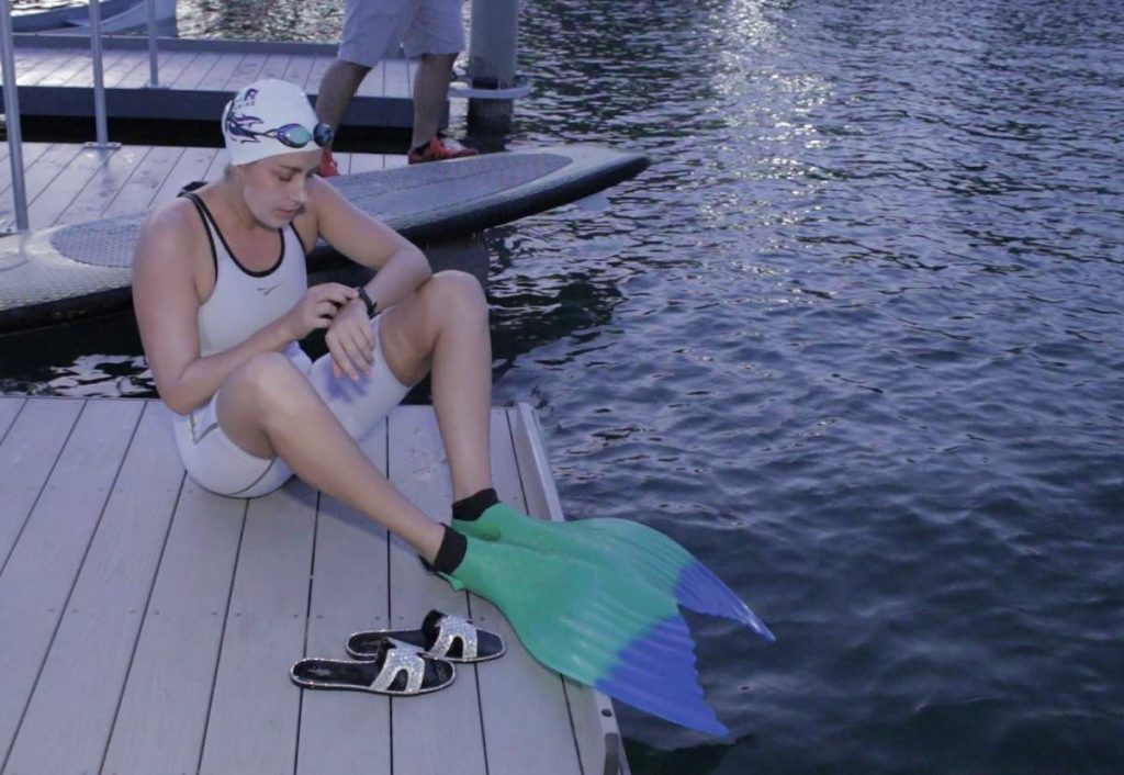 Ms. Liivand sitting on a dock wearing her monofin before setting her record.