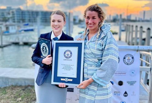 Ms. Liivand (right) stands with a representative of Guinness World Records, holding her award.