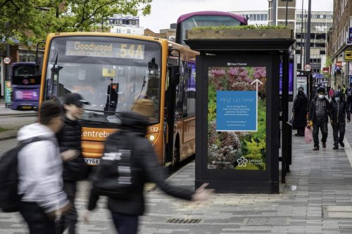 A bus stops at a bee bus stop on a busy street in Leicester, UK.