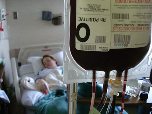 A woman in a hospital gets a blood transfusion.
