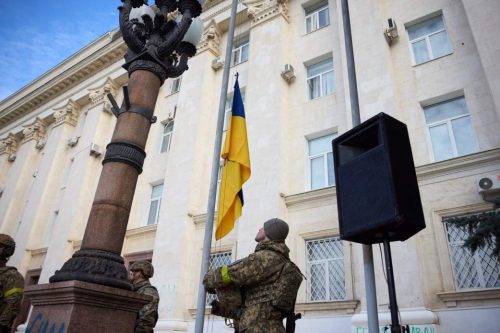During a working trip to the de-occupied Kherson, President of Ukraine Volodymyr Zelenskyy took part in the ceremony of hoisting the State Flag on the central square of the city. The image shows a soldier raising the Ukrainian flag.