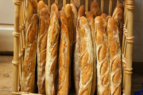 A large batch of vertically stacked baguettes on sale.