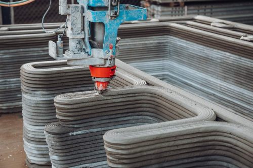 A close shot of the massive 3D printer squirting out concrete.