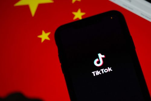 TikTok app on a phone, with a Chinese flag in the background.