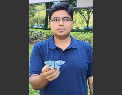 Dr. Debashis Chanda holding a handmade butterfly shape painted with structural paint.