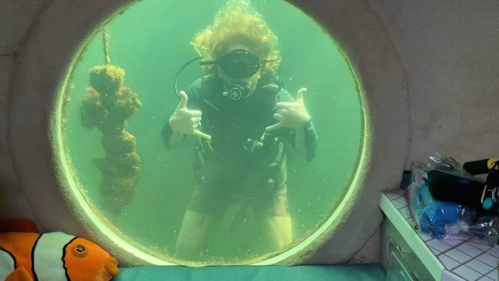 A photo of Dr. Joseph Dituri diving. The picture is taken from inside his underwater home.