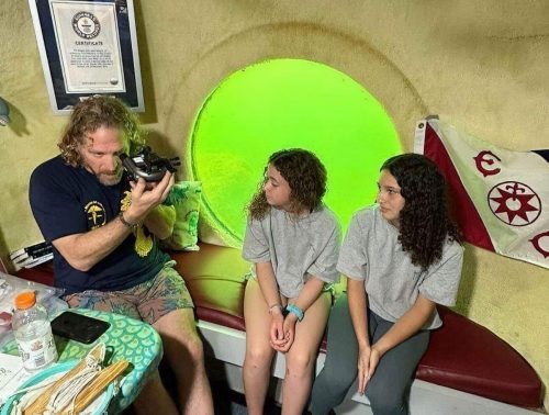 Dr. Joseph Dituri sits in his underwater home with a couple of teenage visitors.