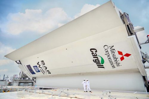 Two workers walk next to a WindWing being retrofitted on Pyxis Ocean at the COSCO shipyard in Shanghai, China.