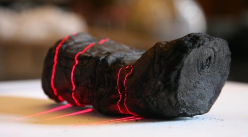 Herculaneum scroll with red laser lines being scanned at Institut de France by Brent Seales and his team.