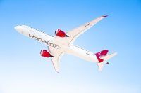 A Virgin Atlantic 787 passenger jet flying across the sky.