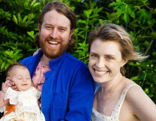 A picture of Casey McIntyre with her husband, Andrew Rose Gregory, who is holding their baby girl, Grace.