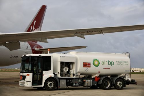 A BP airplane refueling truck labeled "Sustainable Aviation Fuel" is shown in front of a Virgin Atlantic 787.