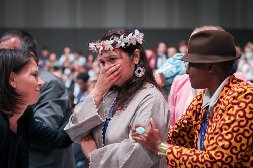 A tearful delegate from the Marshall Islands with a garland of flowers in her hair is comforted as she attends the Closing Plenary at the UN Climate Change Conference COP28 at Expo City Dubai on December 13, 2023, in Dubai, United Arab Emirates.