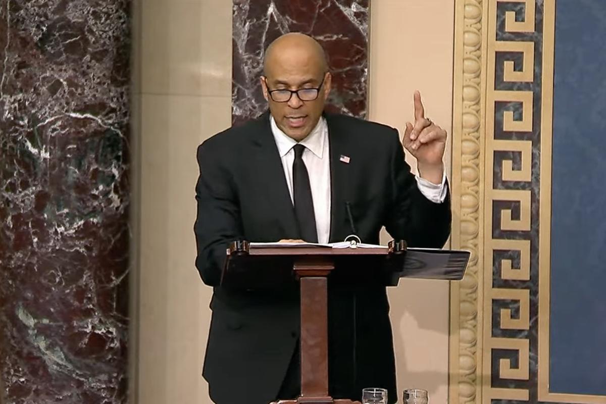Senator Cory Booker reading while giving the longest speech ever given to the US Senate.
