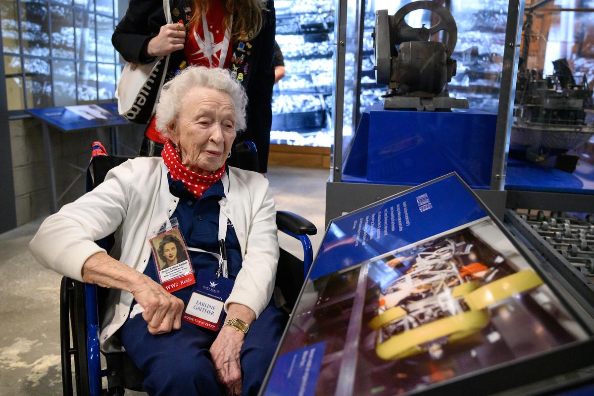 Earline Gaither, who worked as an airplane mechanic during World War II looks at a museum display about the factory where she worked.