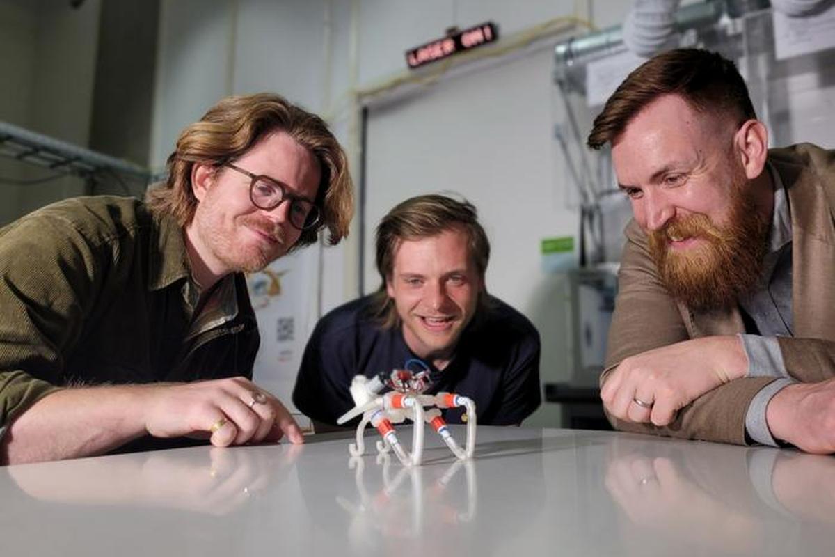 The inventors of the soft robot are seen looking at their creation.