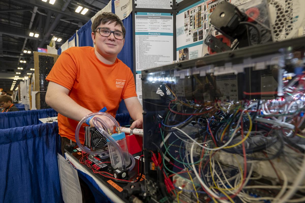 Benjamin Davis with his machine which recycles plastic waste from 3D printing.