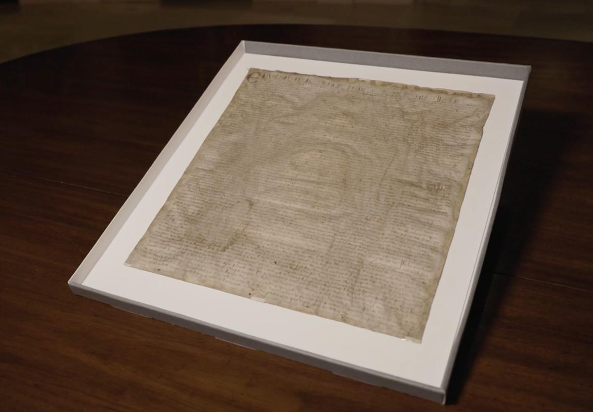 Harvard's Magna Carta is shown framed on a table.
