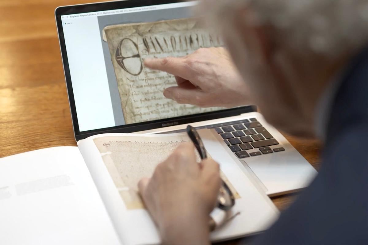 Professor David Carpenter uses a laptop computer to zoom in on a digital image of Harvard's Magna Carta.