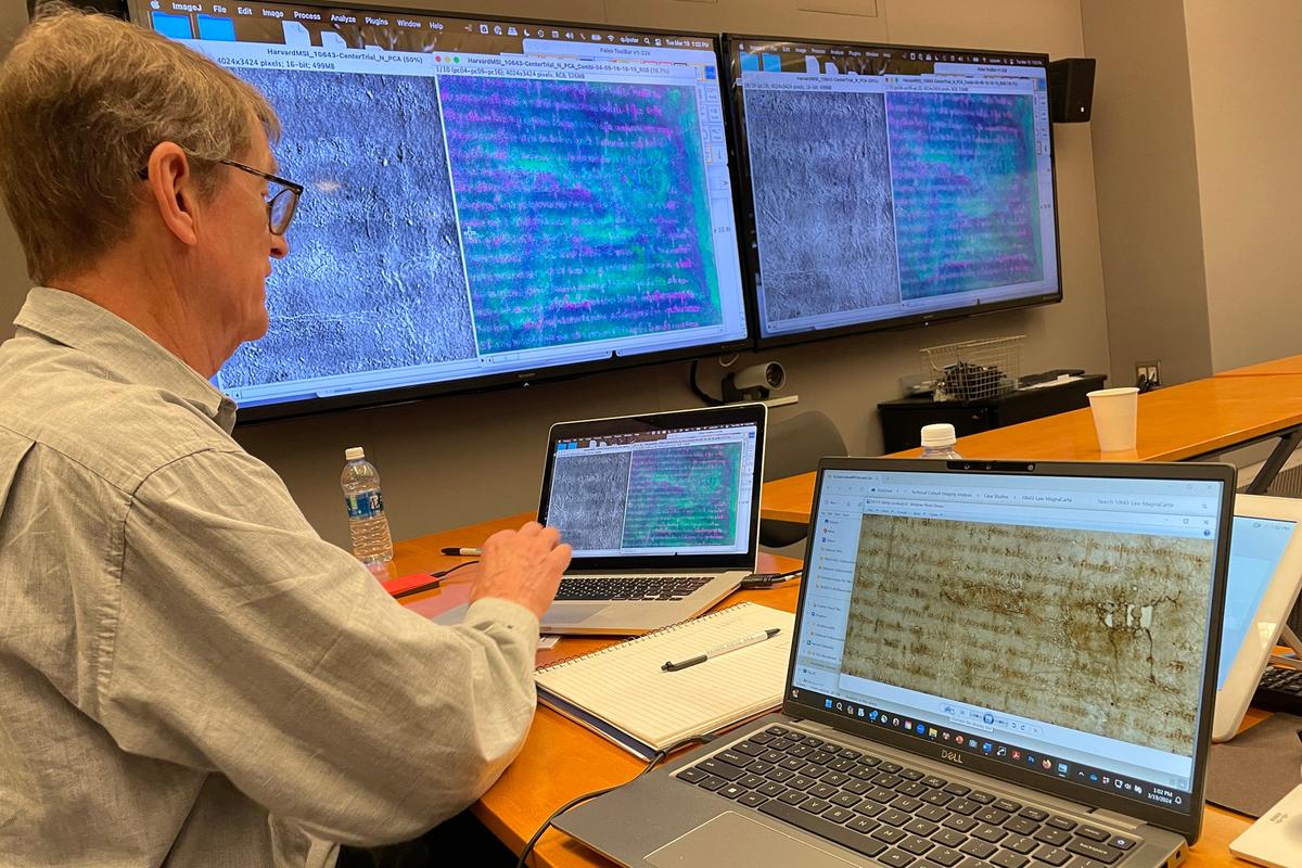 An expert compares images of Harvard's Magna Carta under different lighting conditions.