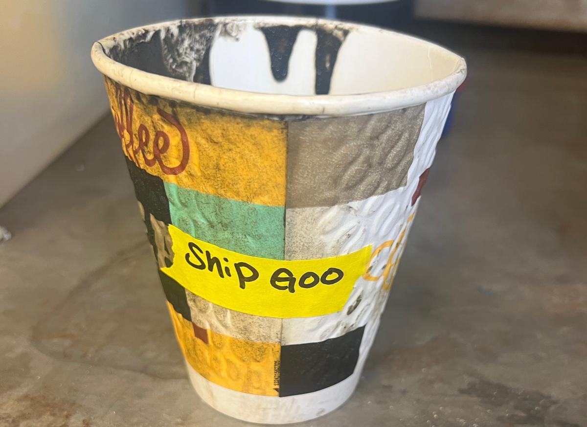 A disposable coffee cup labeled "Ship Goo" that held the sample of the mysterious goo.