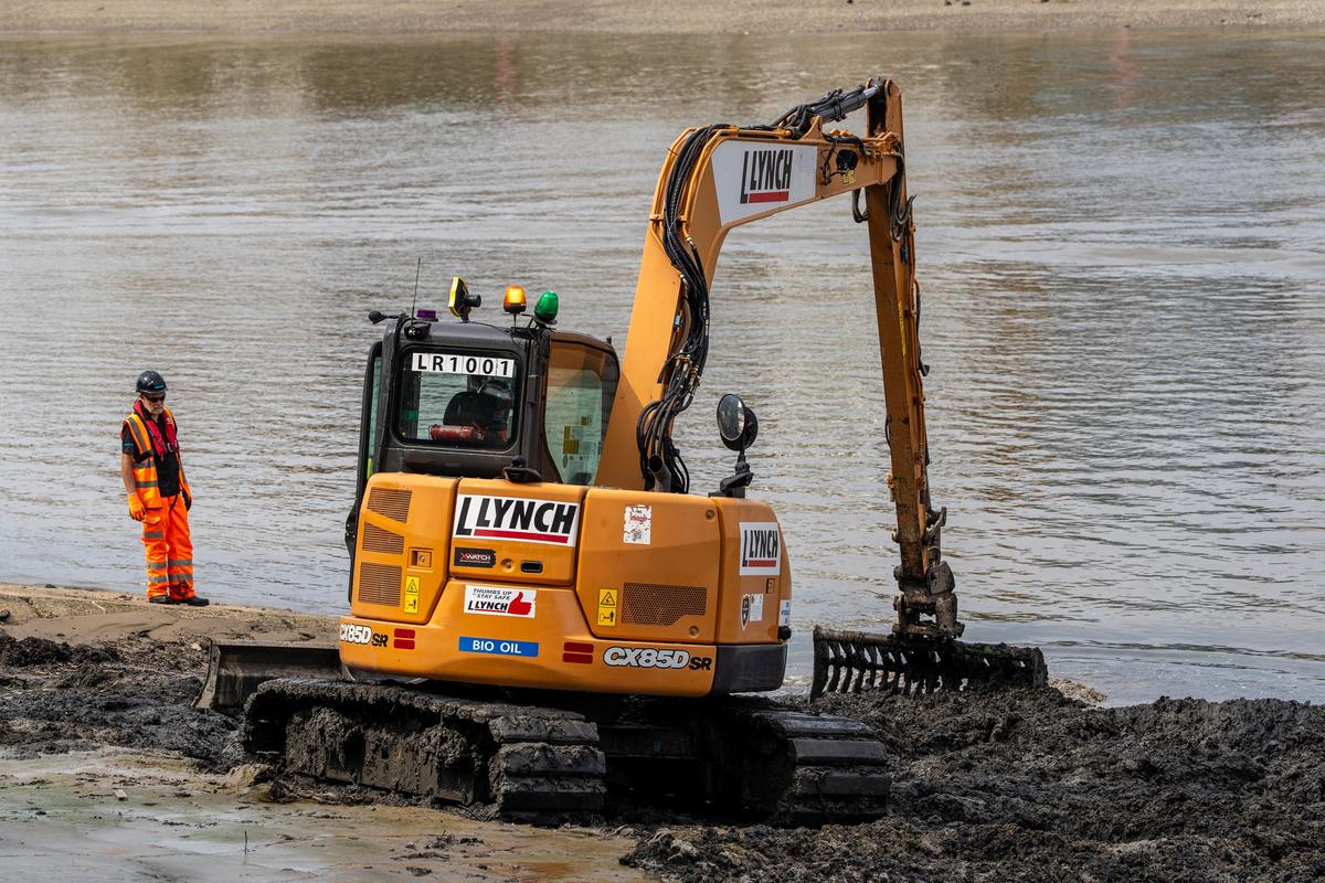 A digger working at Wet Wipe Island near Hammersmith Bridge in London to remove tons of wet wipes.