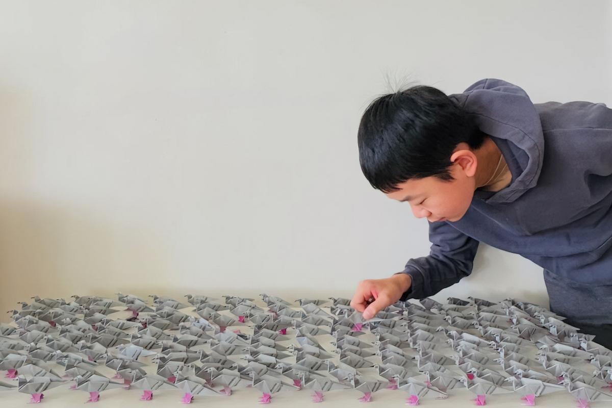 Miles Wu is seen with a collection of origami shapes.