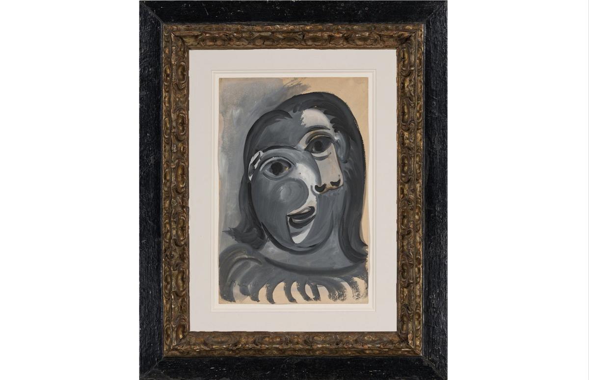 A picture of the framed Picasso painting, Tête de femme ( "Head of a Woman"), a very cubist portrait of a woman's face, in shades of white and grey.