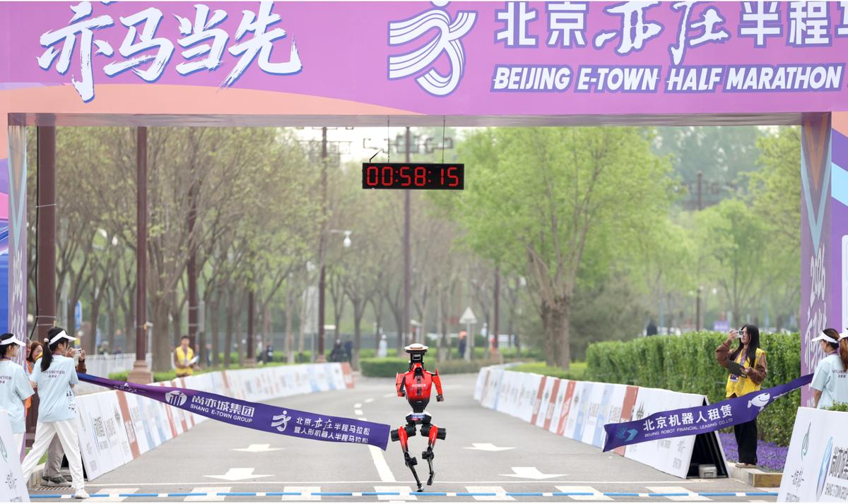 A humanoid robot breaks the tape at the finish line at the 2026 Humanoid Robot Half Marathon in Beijing, China.