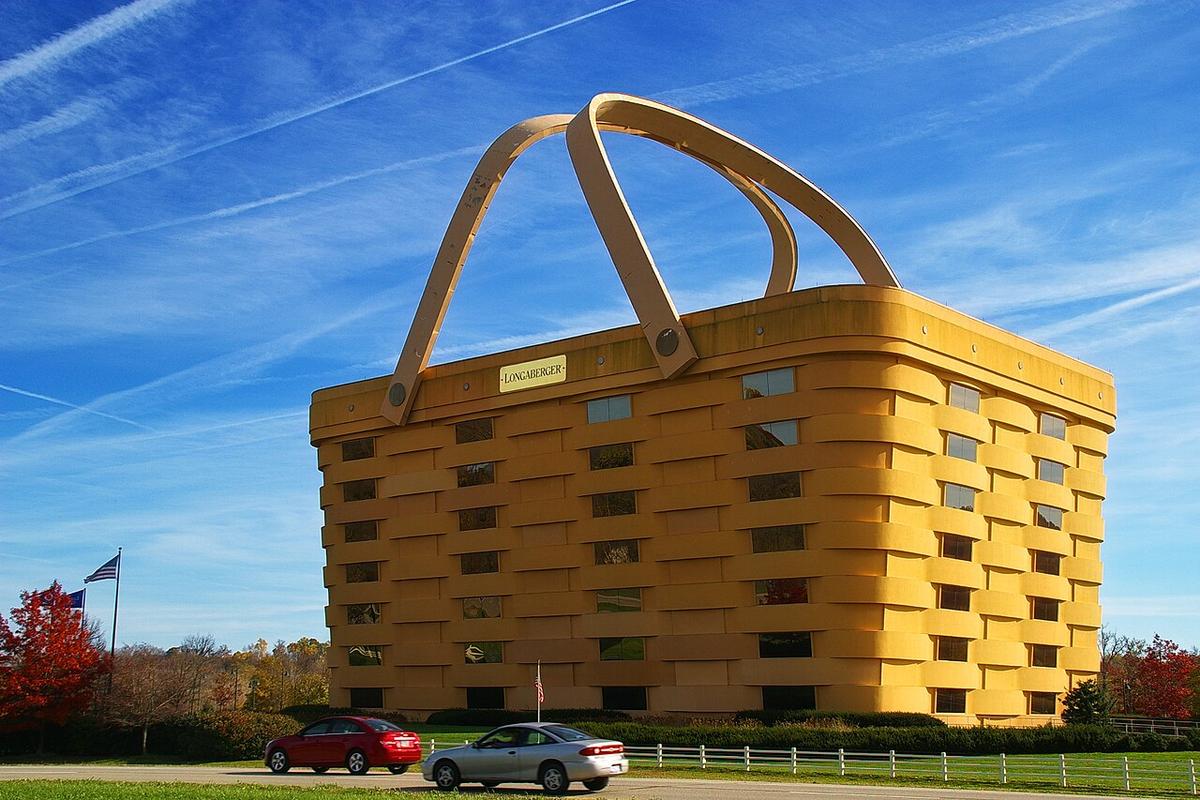 A large, multi-story tan building designed to resemble a woven wicker basket with two handles leaning over its roof.